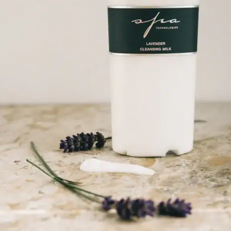 Lavender Cleansing Milk With Fresh Lavender Sprigs Lavender cleansing milk jar with fresh lavender sprigs and cream swatch on marble.